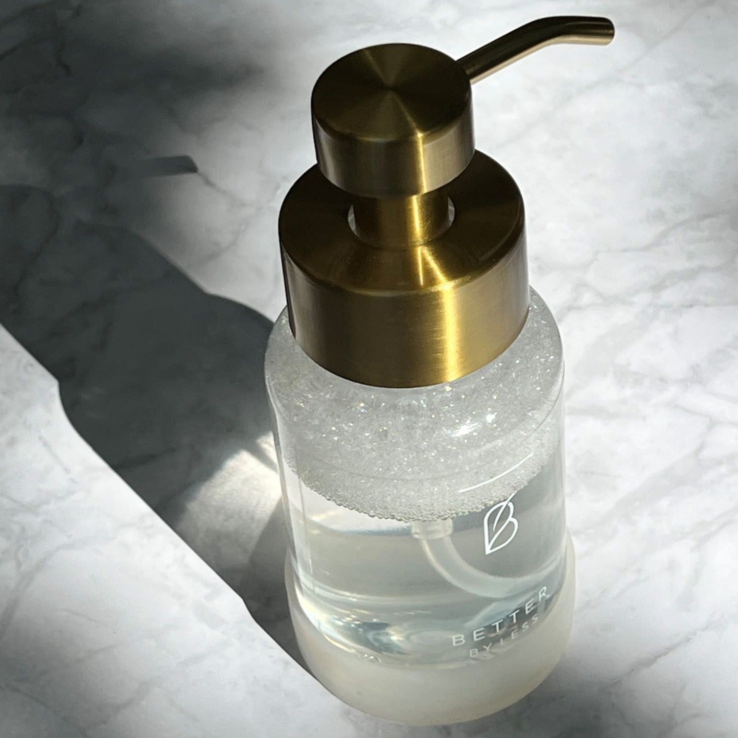 Goldener Spender auf Marmor von Better by Less